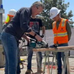 Gavin Newsom using a saw with his body stance very feminine.
