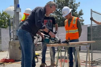 Gavin Newsom using a saw with his body stance very feminine.