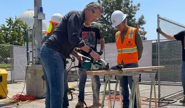 Gavin Newsom using a saw with his body stance very feminine.