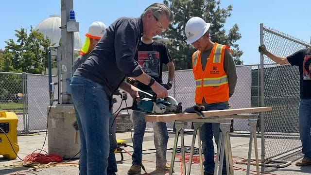 Gavin Newsom using a saw with his body stance very feminine.