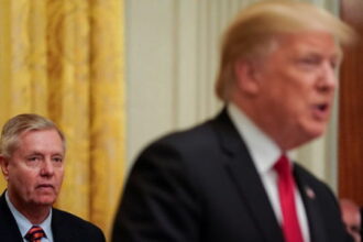 Lindsey Graham, standing behind Donald Trump on stage during Iran peace deal.