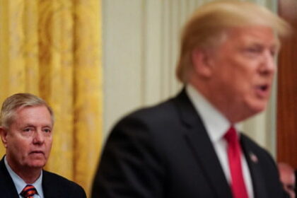 Lindsey Graham, standing behind Donald Trump on stage during Iran peace deal.