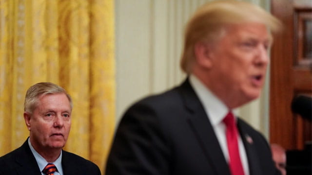 Lindsey Graham, standing behind Donald Trump on stage during Iran peace deal.