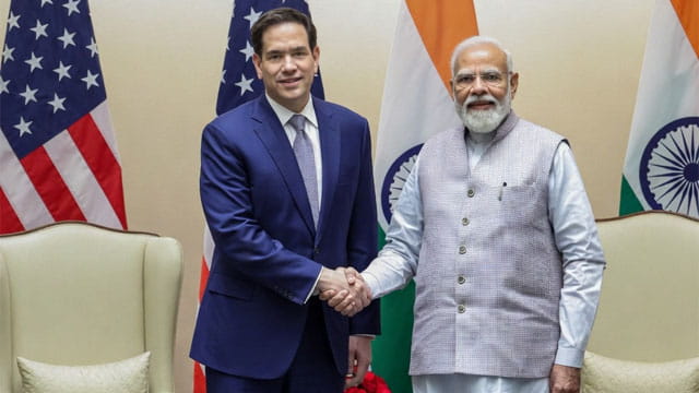 Marco Rubio shaking hands with Indian Prime Minister Modi on stage in front of flags.