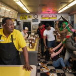 Spirit Airlines black man employee at a Waffle House watching a fight between multiple black men and women.