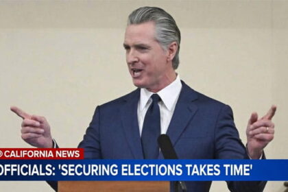 California Governor Gavin Newsom speaking behind a podium on the recent Los Angeles and governor's primary elections.