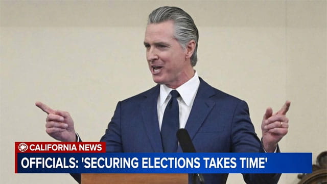 California Governor Gavin Newsom speaking behind a podium on the recent Los Angeles and governor's primary elections.