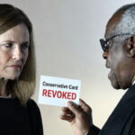 Clarence Thomas and Amy Coney Barrett dressed in black robes speaking.