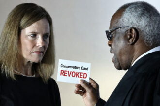 Clarence Thomas and Amy Coney Barrett dressed in black robes speaking.