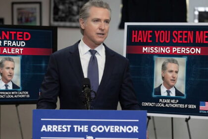 Gavin Newsom standing in front of a podium speaking on California fraud.