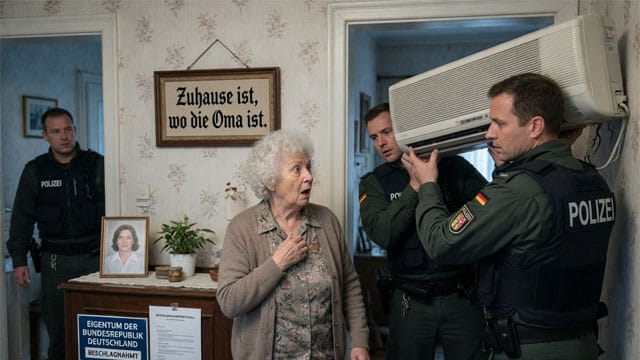 German police raiding a grandmother's home and confiscating her air conditioner.