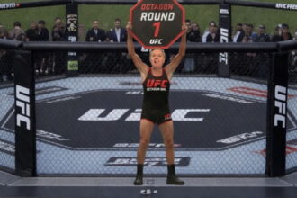Lindsey Graham wearing a Octagon Girl uniform holding up a sign at Trump's UFC Freedom Event.