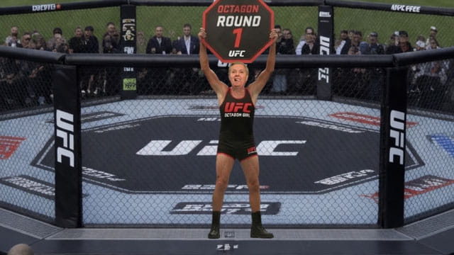 Lindsey Graham wearing a Octagon Girl uniform holding up a sign at Trump's UFC Freedom Event.
