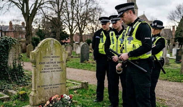 UK police officers standing in front of a tombstone of a deceased white British man inside of a graveyard.