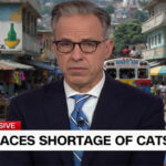CNN Host Jake Tapper in front of a Haiti city street.