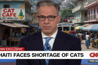 CNN Host Jake Tapper in front of a Haiti city street.