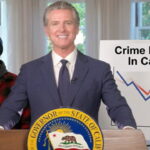 California Governor Gavin Newsom wearing a suit standing behind a podium and a male black Somali man on stage.