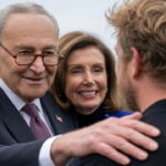 Democrats Chuck Schumer and Nancy Pelosi standing in front of Graham Platner.