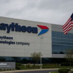 Raytheon building with an American flag at half-mast in memory of deceased Lindsey Graham.