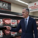 Canada Prime Minister Mark Carney standing in front of a grocery store meat case.