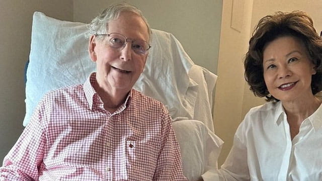 Mitch McConnell in the hospital on a chair sitting next to his Chinese wife.
