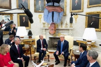 RFK Jr. sleeping upside down from the Oval Office ceiling like a bat as President Trump and Cabinet members down below hold a meeting.
