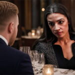 AOC and her fiancé in a restaurant seated at a table.