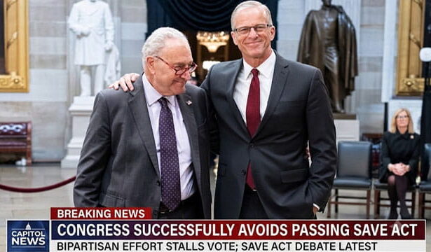 Congress members John Thune and Chuck Schumer hugging one another in Capitol Hill.