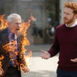 Dr. Fauci bursts into flames near white man outside Congressional hearing building.