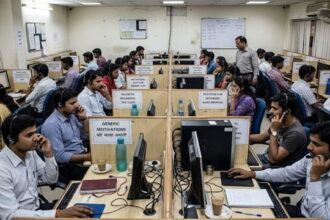 India scam call center with male and female workers on phones.