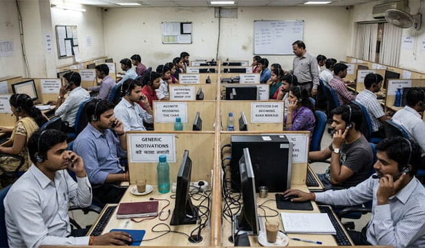 India scam call center with male and female workers on phones.