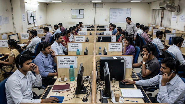 India scam call center with male and female workers on phones.