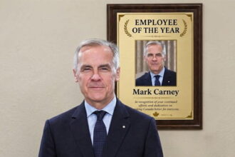 Canada Prime Minister Mark Carney standing in front of a placard of himself.