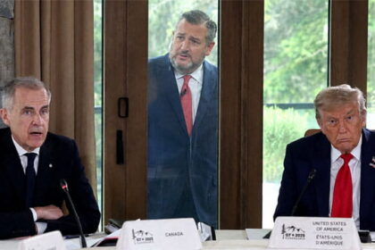 Donald Trump and Mark Carney sitting at a table talking while Ted Cruz stands outside of a window looking inside.