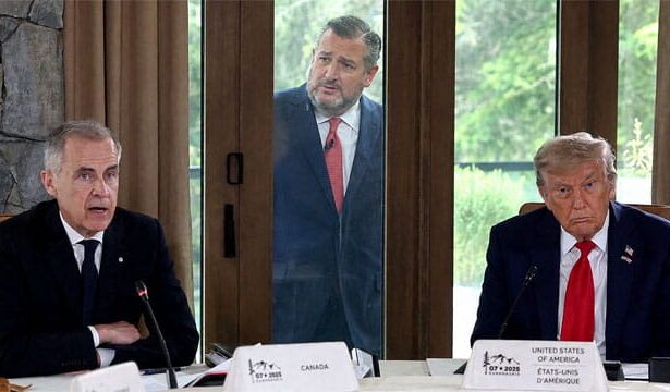 Donald Trump and Mark Carney sitting at a table talking while Ted Cruz stands outside of a window looking inside.
