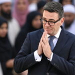 UK Prime Minister Andy Burnham standing in front of Muslim voters.