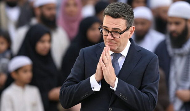 UK Prime Minister Andy Burnham standing in front of Muslim voters.