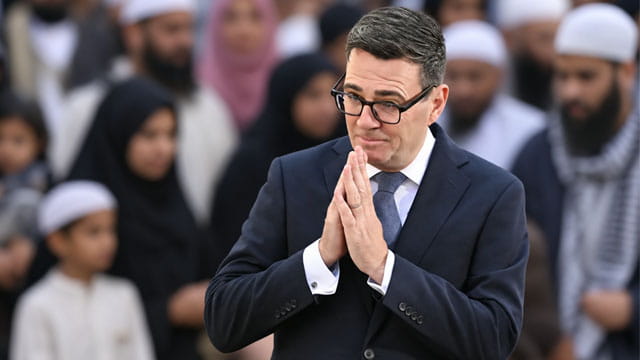 UK Prime Minister Andy Burnham standing in front of Muslim voters.