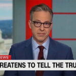 CNN anchor Jake Tapper in a suit reporting on President Trump's press ban.