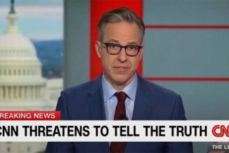 CNN anchor Jake Tapper in a suit reporting on President Trump's press ban.