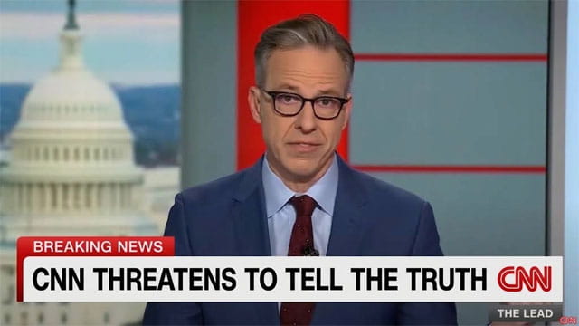 CNN anchor Jake Tapper in a suit reporting on President Trump's press ban.