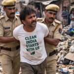 India man being arrested by Indian police in a trash covered poor India city.