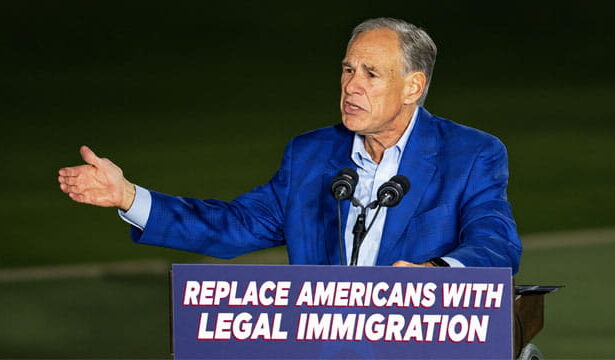 Republicans Greg Abbott on stage giving a speech on immigration.