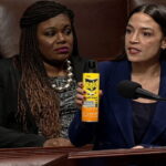 Female Congresswoman AOC holding a can of RAID bug spray inside of Congress speaking.