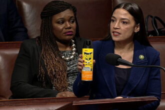 Female Congresswoman AOC holding a can of RAID bug spray inside of Congress speaking.