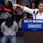 Male Muslim Abdul El-Sayed giving a speech during a rally with people in the background.