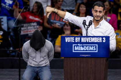 Male Muslim Abdul El-Sayed giving a speech during a rally with people in the background.