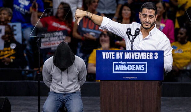 Male Muslim Abdul El-Sayed giving a speech during a rally with people in the background.