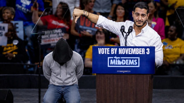 Male Muslim Abdul El-Sayed giving a speech during a rally with people in the background.