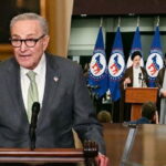 Democrat politicians standing behind podium in front of sign board with the Iran letter to American people.